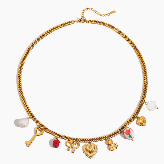 Gold chain necklace with various charms on a white background