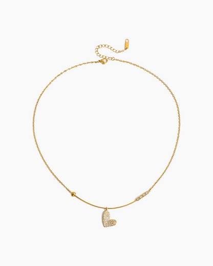Gold necklace with a heart-shaped pendant on a white background