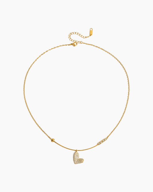 Gold necklace with a heart-shaped pendant on a white background
