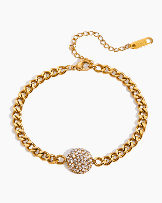 Gold chain bracelet with a decorative clasp on a white background