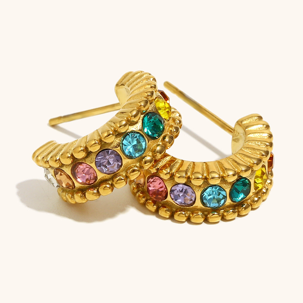 Small chunky golden hoops with rainbow zirconia stones on white background