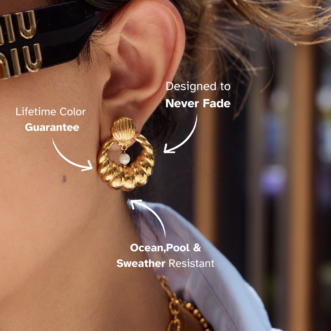 Elegant marine-style gold earrings worn by woman outdoors