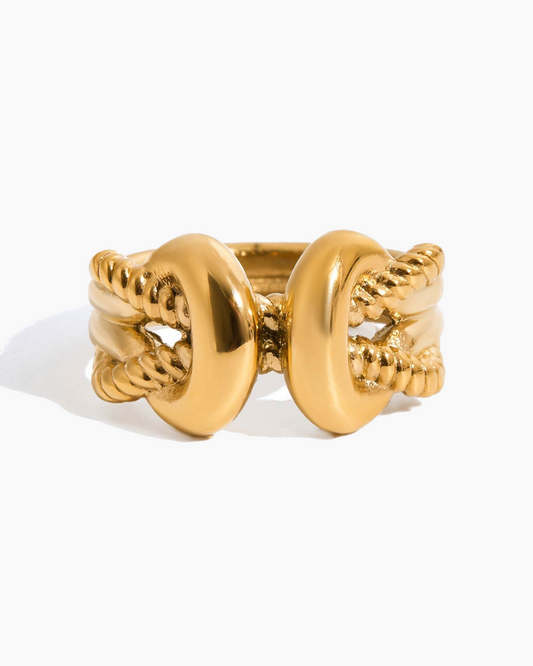 Gold ring with intricate design on a white background