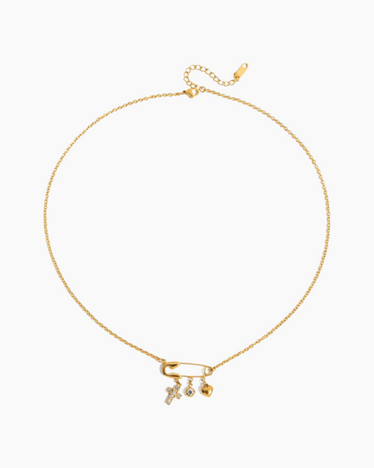 Gold necklace with three small pendants on a white background