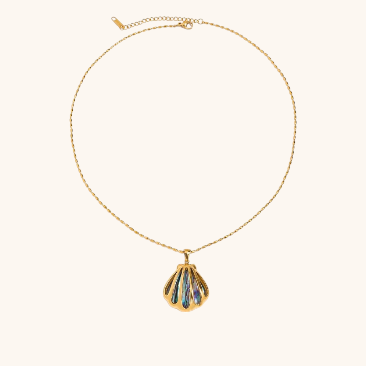 Close-up of gold shell necklace with iridescent abalone inlay on plain background