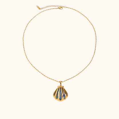 Close-up of gold shell necklace with iridescent abalone inlay on plain background