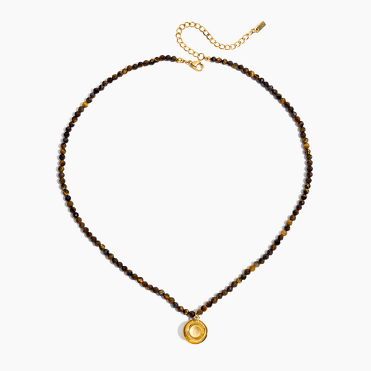 Necklace with brown beads and a gold pendant on a white background