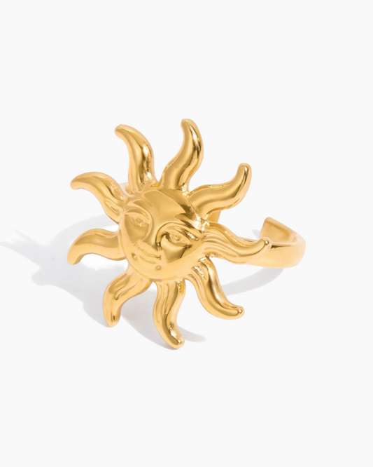 Gold sun-shaped ring on a white background