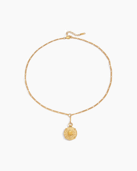 Gold necklace with a round pendant on a white background
