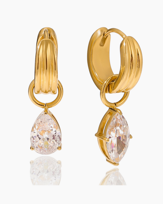 Gold hoop earrings with teardrop-shaped crystals on a white background