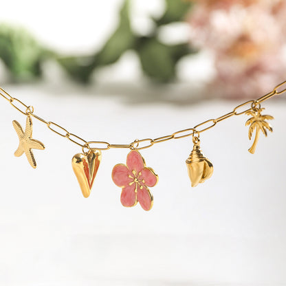 Product display of gold necklace with pink flower, palm, heart, shell, and starfish charms