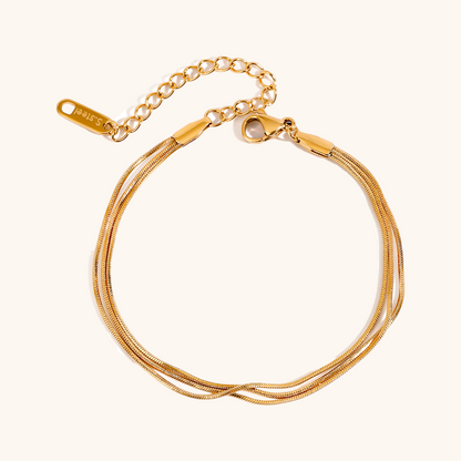 Close-up of gold twisted snake chain bracelet on white background