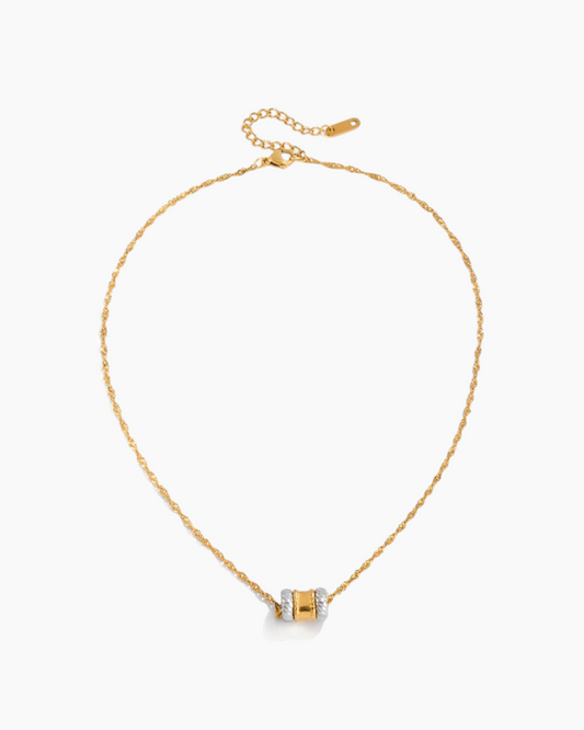 Gold necklace with a small pendant on a white background