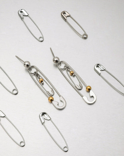 Close-up of silver drop earrings styled with punk-inspired details