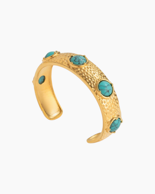 Gold bracelet with turquoise stones on a white background