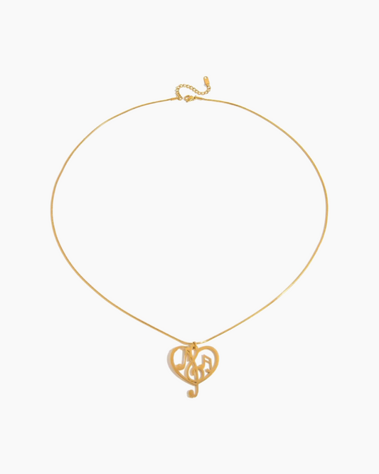 Gold necklace with a heart-shaped pendant on a white background