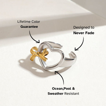 Gold and silver heart-shaped open ring with a bow on white background