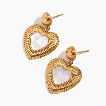 Gold heart-shaped earrings with a white center on a white background