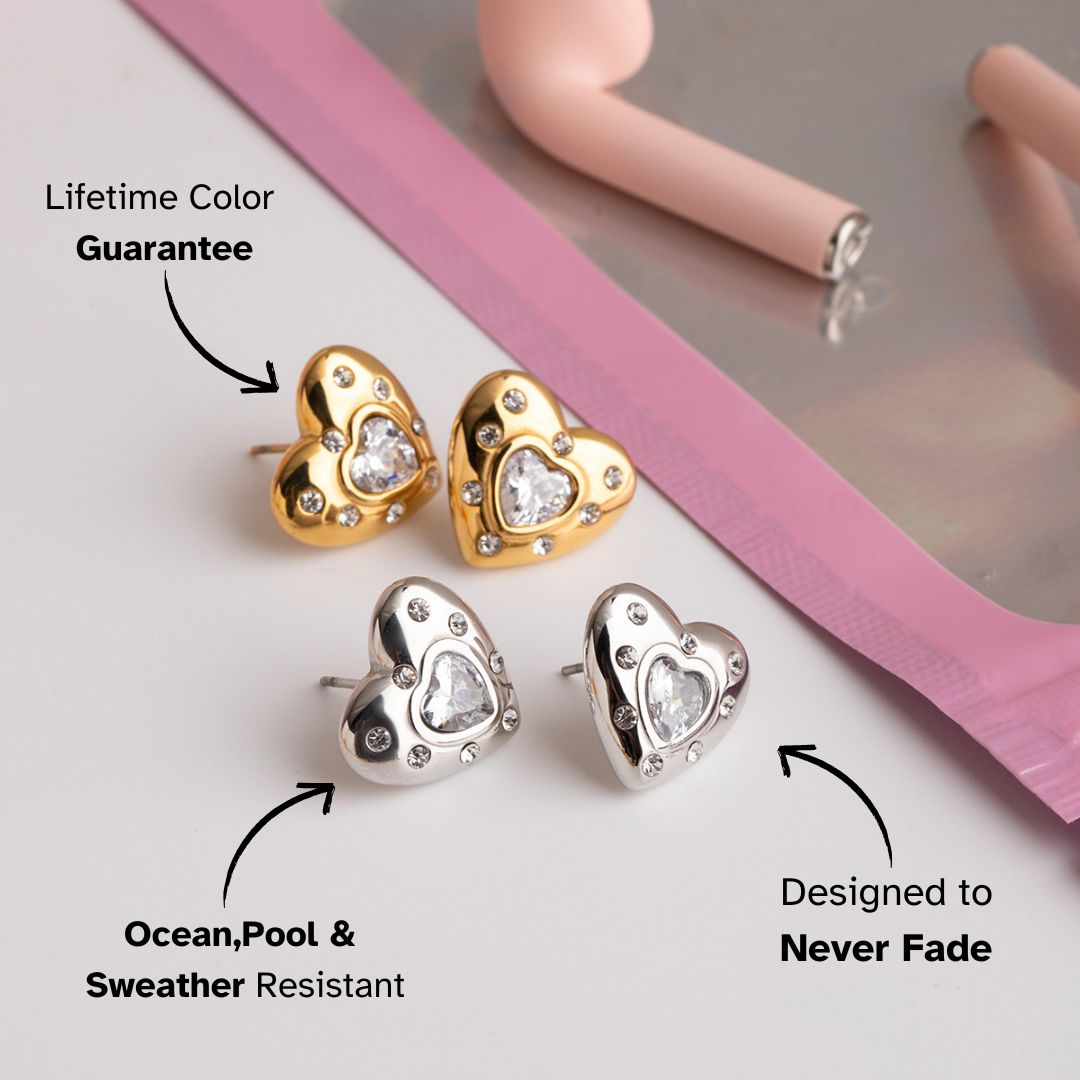 Mixed gold and silver heart studs with sparkly center stones, styled next to charm bracelets