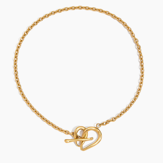 Gold bracelet with a heart-shaped clasp on a white background