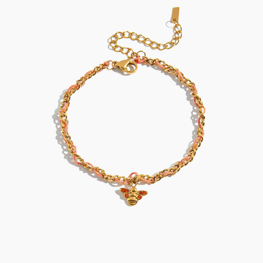 Gold chain bracelet with a bee charm on a white background