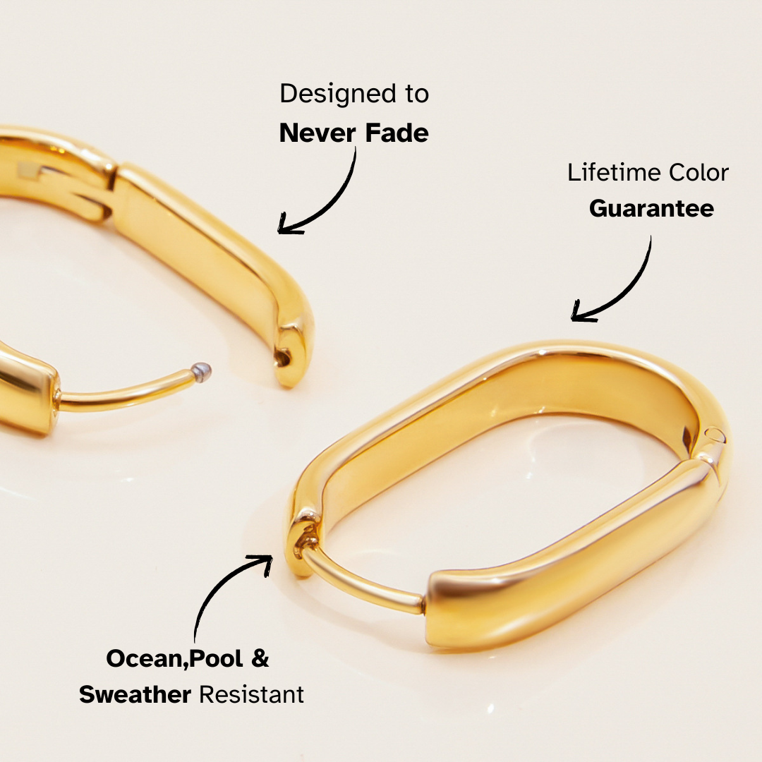 Sleek gold huggie earrings standing upright with glossy finish