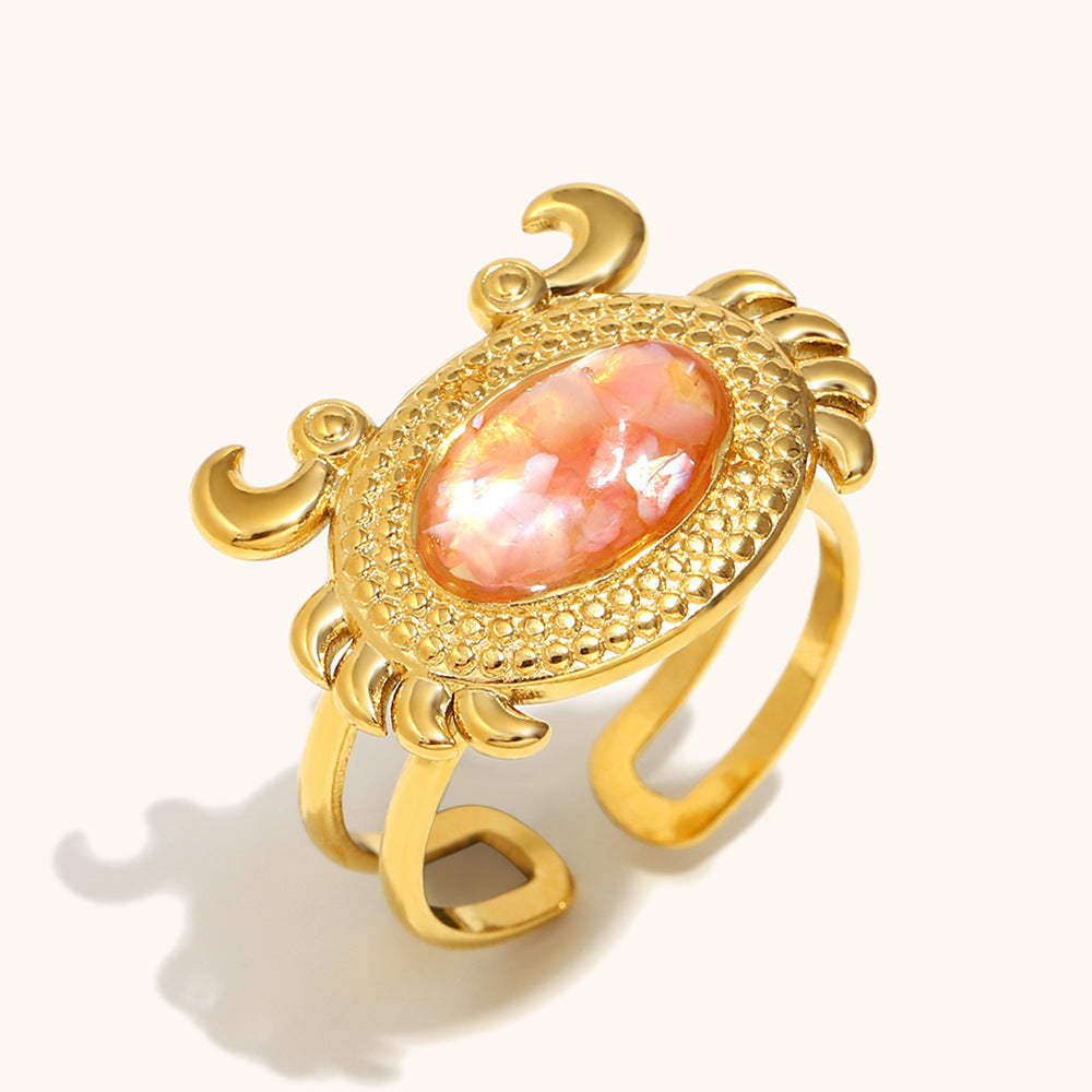 Adjustable pink shell ring with gold crab detailing, summer-ready accessory.