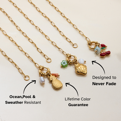 Gold necklaces with various charms on a light beige background