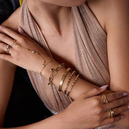 elegant gold bracelet set with heart charm on model in evening gown