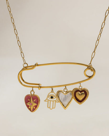 Gold pendant necklace featuring four hanging charms on a pin