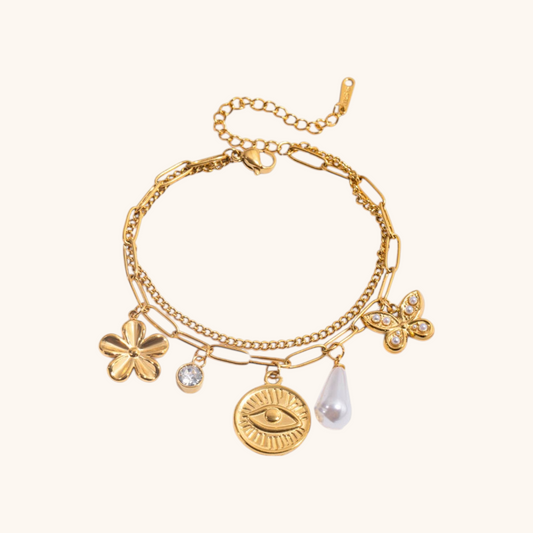 Gold bracelets with ocean-themed charms like shells and coral worn with a navy summer dress