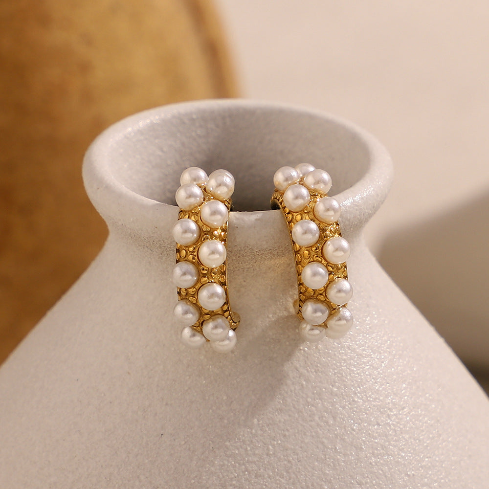 Artistic shot of pearl-studded hoops displayed on pottery