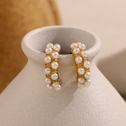 Artistic shot of pearl-studded hoops displayed on pottery