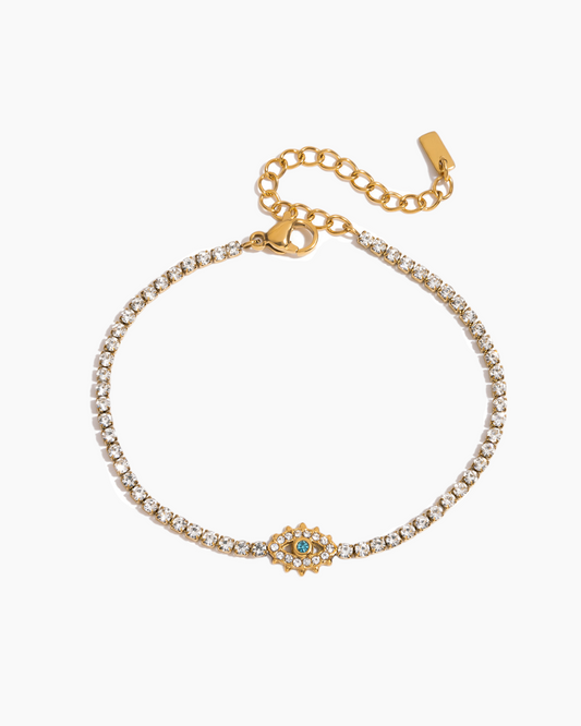 Gold bracelet with a decorative clasp on a white background