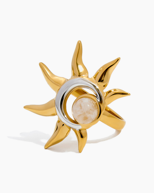 Gold and silver ring with a central stone on a white background