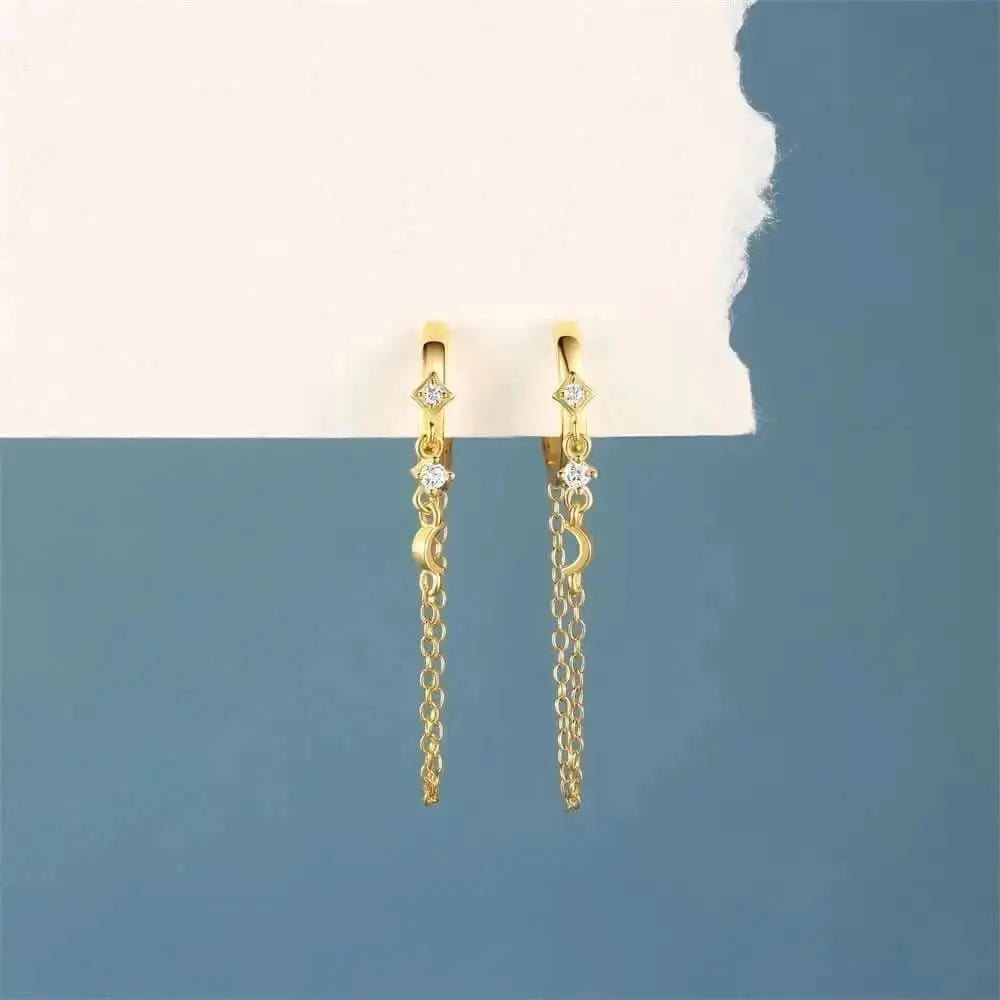 Make a stellar statement with these moon and star chain hoop earrings in gold