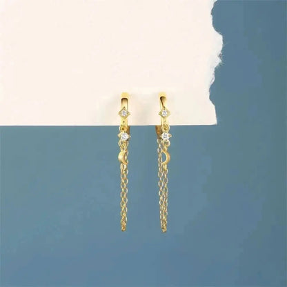 Make a stellar statement with these moon and star chain hoop earrings in gold