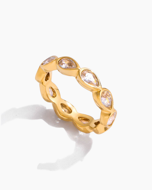 Gold ring with clear gemstones on a white background