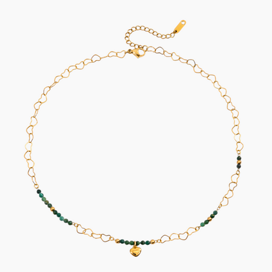 Gold chain necklace with green beads on a white background