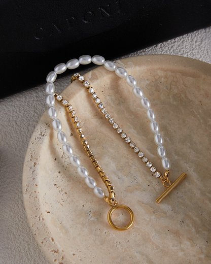 Pearl and gold bracelet on a textured surface with 'Cachet' branding.