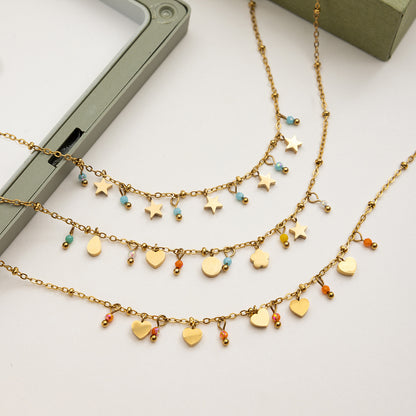 Close-up of gold star charm necklace with blue beads on plate