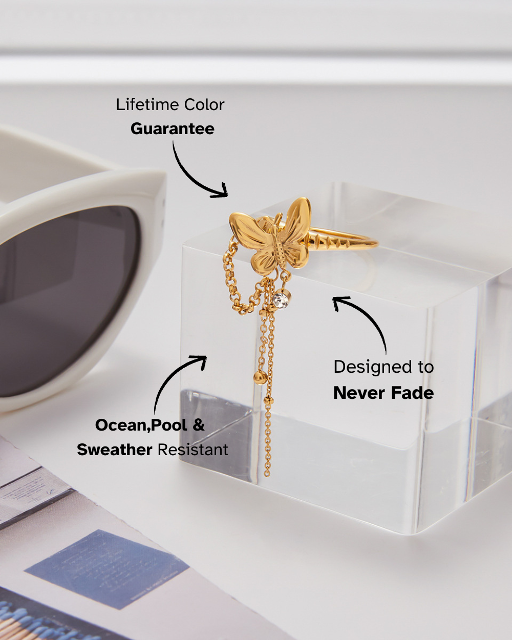 Gold butterfly earring with chain on a white surface, surrounded by text about product features.