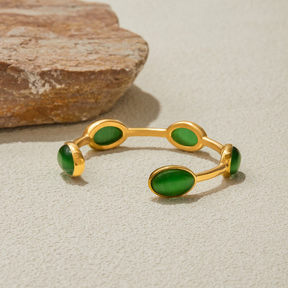 Simple open cuff bracelet featuring five green gemstone accents