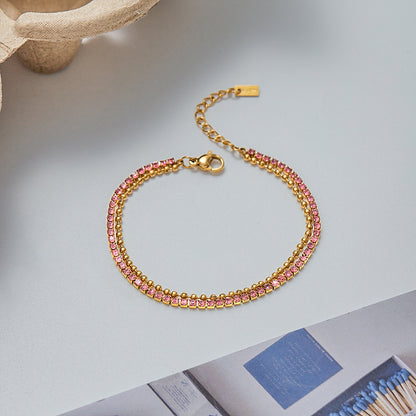 Gold minimalist beaded bracelet with geometric finish laid flat on surface