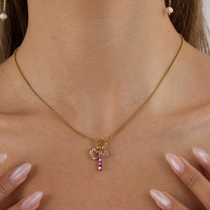 Flat lay of heart and bar pink pendant necklace on light background