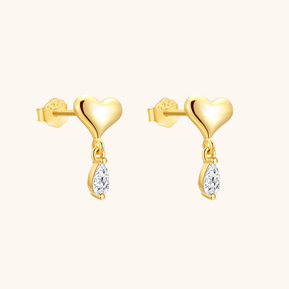 Elegant model with sleek blonde hair wearing minimalist heart-shaped drop earrings