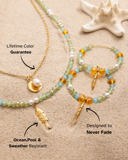 Jewelry set including necklace, bracelet, and earrings on sand with starfish