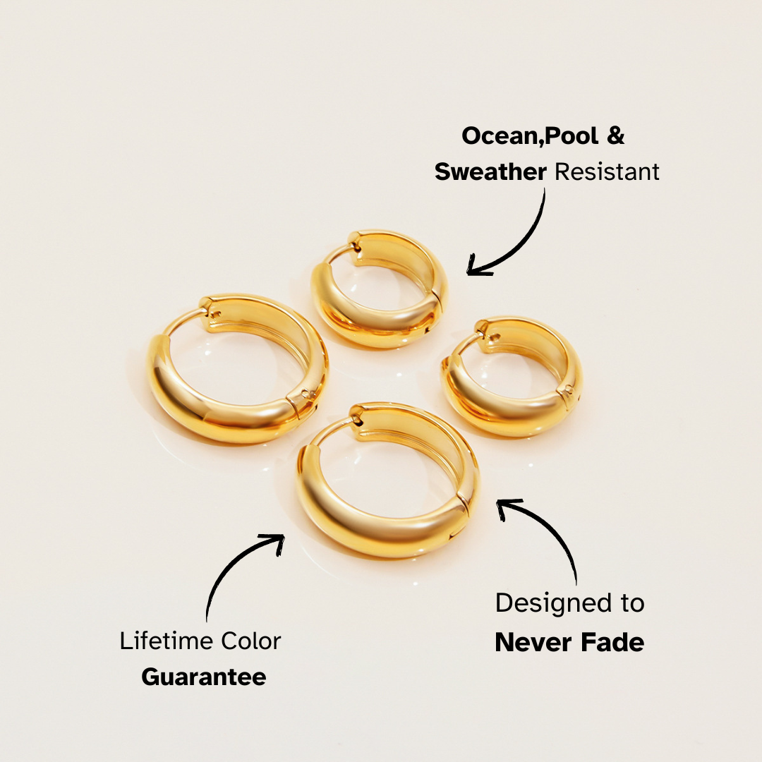 Gold dome hoop earrings on reflective surface