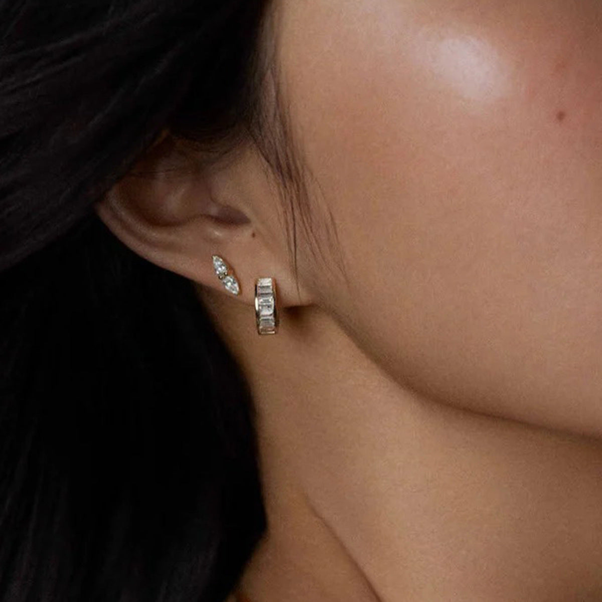 Everyday gold huggies styled with layered ear piercings