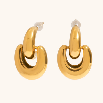 pair of modern gold geometric earrings on neutral backdrop